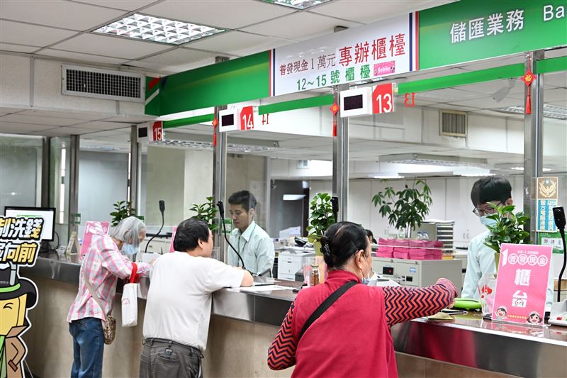 中華郵政今(24)日啟動臨櫃領現，首週採證號末碼單雙號分流，全台1292間郵局秩序良好。董事長王國材親視察，確認每人實際辦理時間皆在3分鐘內完成。截至下午1時，郵局各管道總領取數已飆破555萬筆，臨櫃佔27.3萬筆。郵局將持續以最高標準確保作業圓滿，並贈送精美紅包袋紀念。（圖／中華郵政提供）