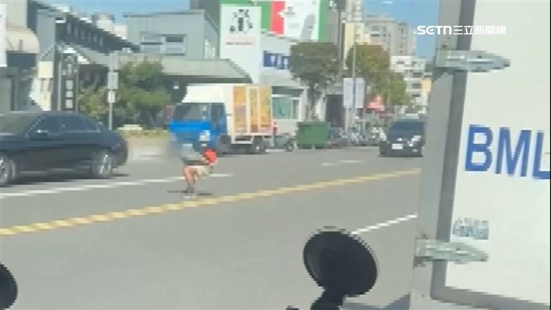 男子在道路中間青蛙跳