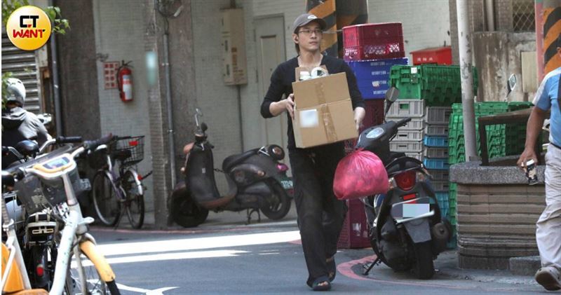 張立昂拿著一箱回收物、一袋垃圾走到巷口。（圖／CTWANT）