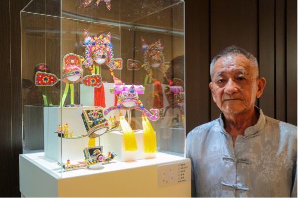 高雄市布袋戲偶盔帽製作技術保存者蘇志榮與作品。(圖/翻攝自高雄市立歷史博物館)