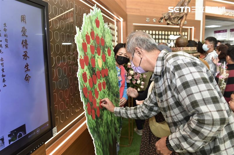 眾人在生命樹上掛上祈福蘋果卡，象徵愛的延續與生命不息。（圖／奇美醫院提供）