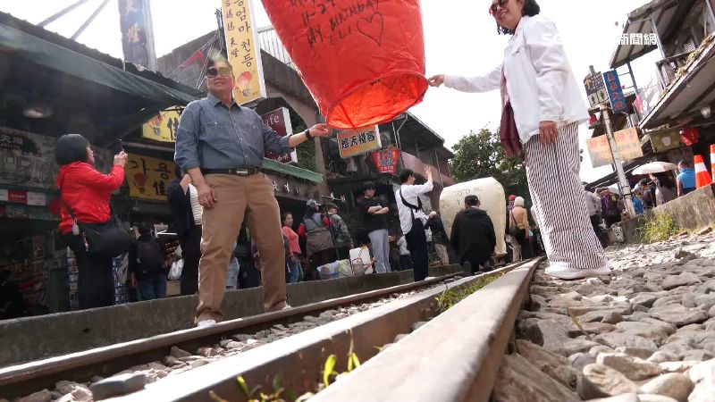許多遊客會站在鐵軌上放天燈