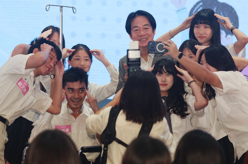 總統賴清德（後右2）近距離與年輕世代互動交流，並和學生們開心自拍留念