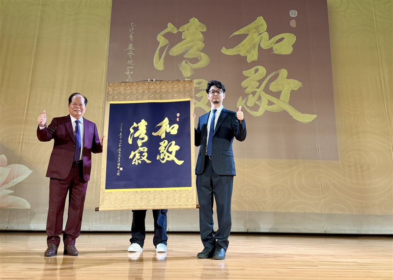 右一為日台交流協會新聞文化部長荒木直哉，左為林暉博士，雙方於典禮中共同展示林博士親題書法作品〈和敬清寂〉，象徵日台文化交流的誠意與友誼。（圖／必紅演藝提供）