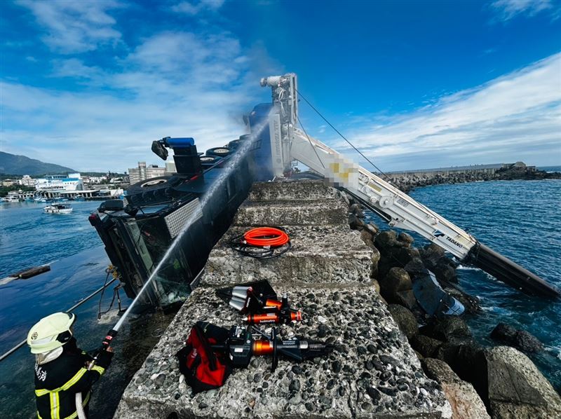 台東成功漁港吊車時翻覆，期間一度起火燃燒，受困工人釀1死1傷。（圖／翻攝畫面）