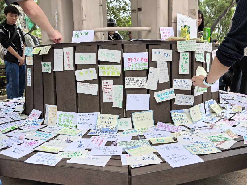 香港宏福苑26日發生奪命大火，市民30日前往現場悼念，圖為市民在大火附近公園的坐椅貼上悼念卡