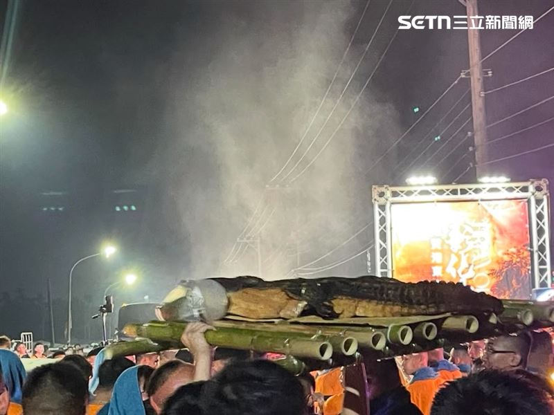 整隻鱷魚成為廟會供品超吸睛，信徒圍觀搶拍。（圖／記者朱俊傑攝影）