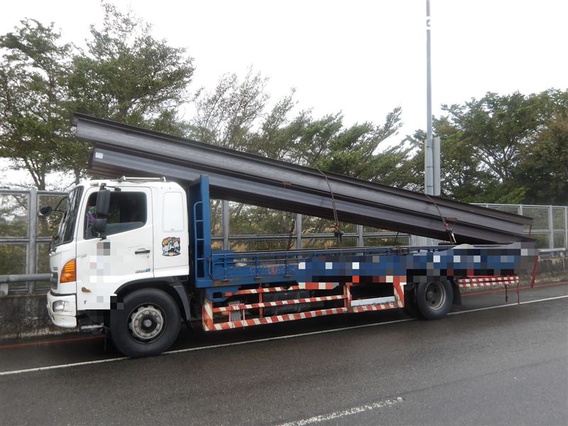 白色轎車路口撞斷號誌桿，害電纜線垂落，路過大貨車貨物纏繞電纜線又扯斷另一支號誌桿。（圖／翻攝畫面）