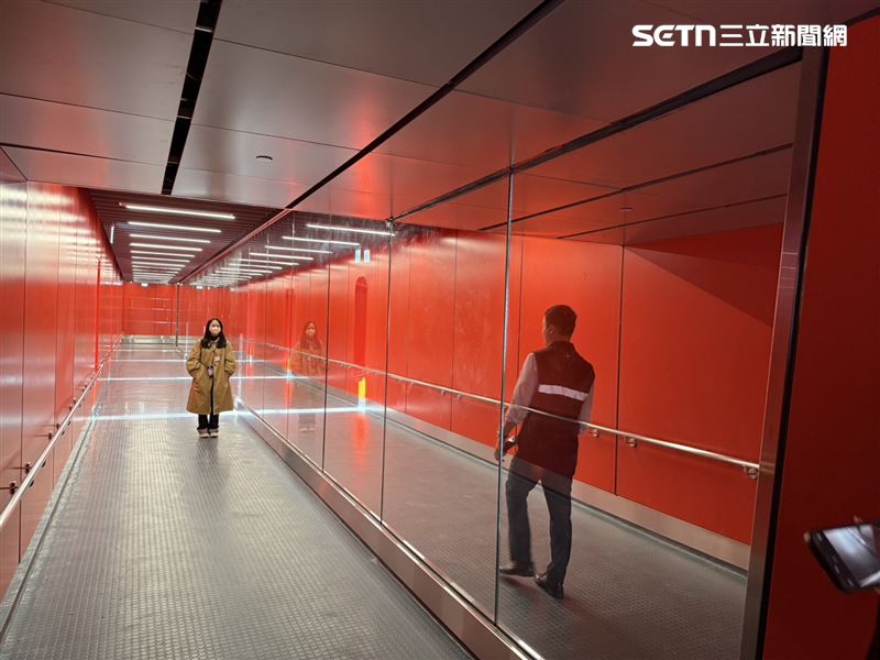 北登廊廳空橋相當寬敞，色系以橘紅色為主體，其中D14分為D14L與D14R空橋中間為透明玻璃。（圖／記者李育道攝影）