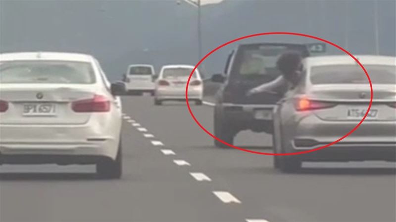 銀色轎車後座乘客朝白車丟擲水球。（圖／翻攝自臉書爆料公社）