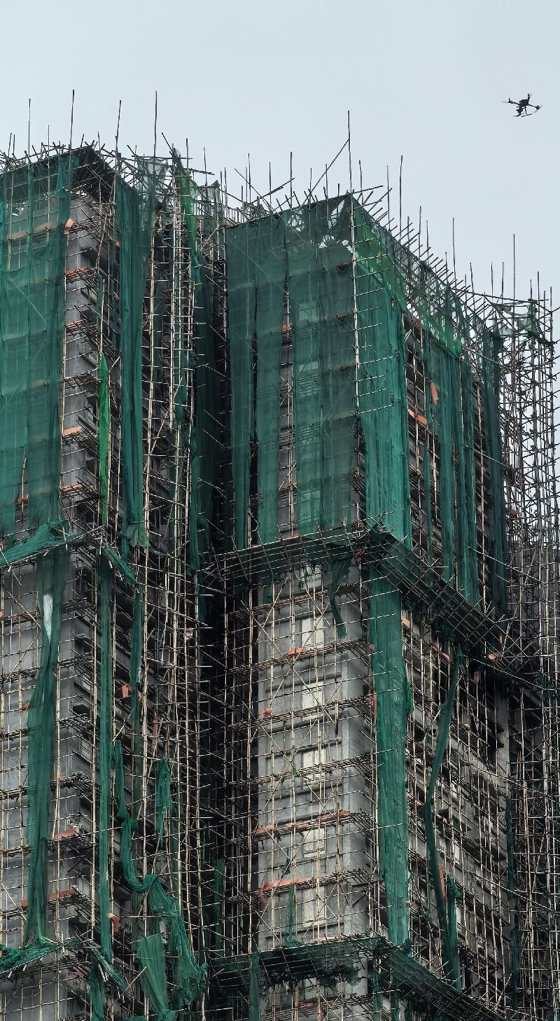 香港大埔宏福苑大火慘劇發生後，由於有證據顯示部分棚網在阻燃檢測方面有造假情況，港府勒令所有在維修之中的大樓棚網全部下架；圖為宏福苑在大火後殘存的棚網