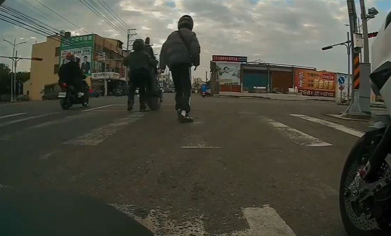 機車翹孤輪後失控暴衝，騎士被硬拖往前好幾步，機車呈現直立90度滑行姿態。(圖／翻攝自記者爆料網)