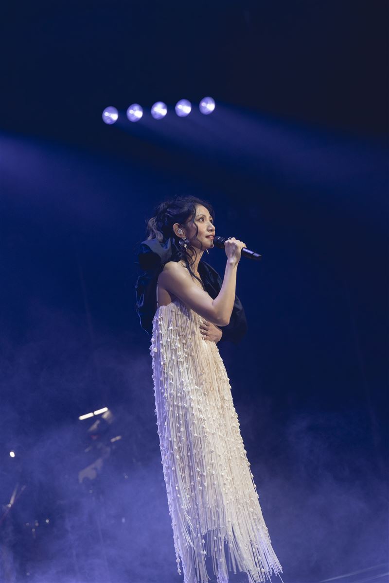 李千娜身穿米白色流蘇長洋裝，隨著身體搖曳堆疊豐富情感。（圖／寬宏藝術X環球音樂提供）