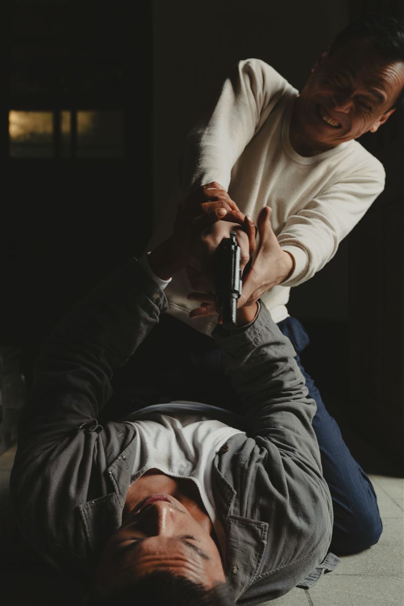 柯煒林(下)被陳以文(上)拖住跨坐壓制,除了激烈拉扯還要死命抵抗陳以文開槍。(圖/華文創 提供)