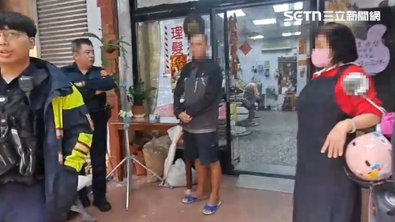 霸王理髮的男子跟員警、老闆娘僵持在店門口。(圖/翻攝畫面)