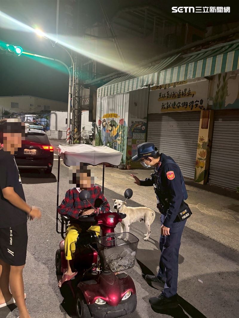 擔心著涼，先將老婦攙扶上巡邏車，一旁的愛犬「小白」卻不願上車，反而在車頭前方不斷徘徊並頻頻回頭張望。（圖／翻攝畫面）