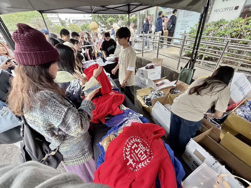 輔仁大學百年校慶園遊會13日舉行，校方表示，不少攤位熱門，也有學生與校友選購有紀念意義的輔大紀念帽T恤。（輔仁大學提供）