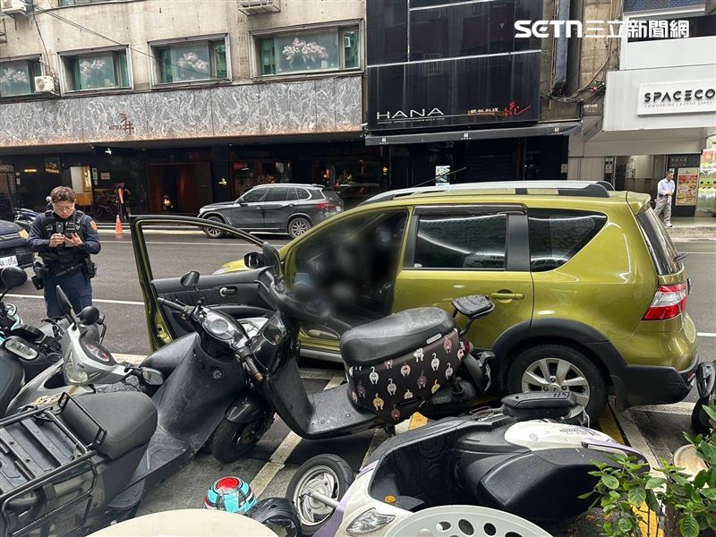 北市張婦下車問路卻未拉手煞車,結果車輛倒退滑行撞翻7輛機車。(圖/翻攝畫面)