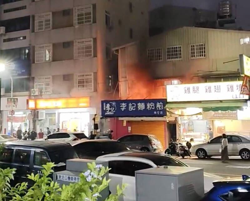 「李記麵粉煎」南屯店發生火災,一旁的南屯派出所員警帶滅火器壓制火勢。(圖/翻攝畫面)