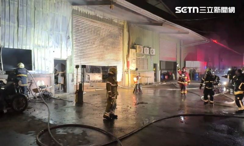 消防局出動23車47人前往搶救,用破壞器材將鐵門切割出一個大洞入內射水。(圖/翻攝畫面)