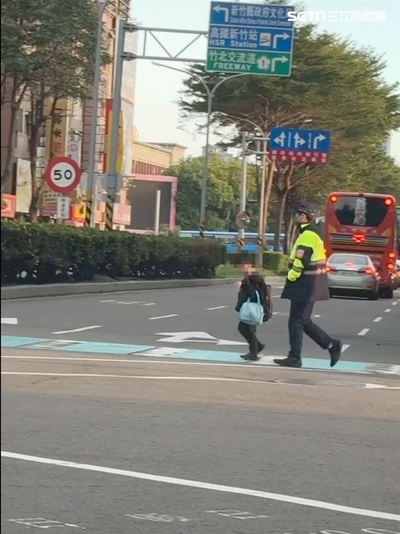 綠燈一亮,員警默默地跟在男童後面,雖沒有對話,卻是最暖心的畫面。(圖/網友___.gladys授權提供)