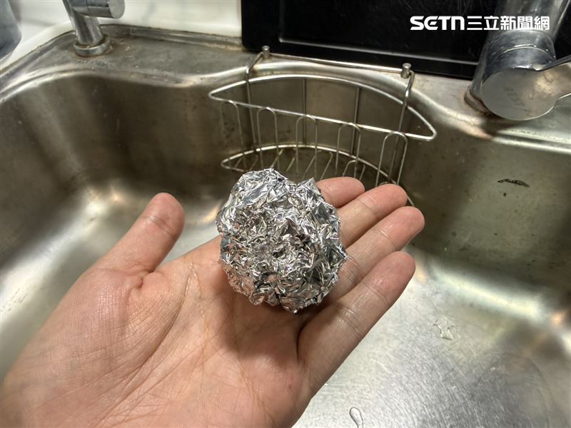 有民眾分享，將不要的鋁箔紙揉成球狀，放入廚房水槽的濾水籃中，就能有效減少油汙、黏液與異味。（圖／記者李育道攝影）