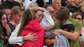 人們聚集為罹難者悼念，情緒激動悲傷。（圖／美聯社／達志影像）