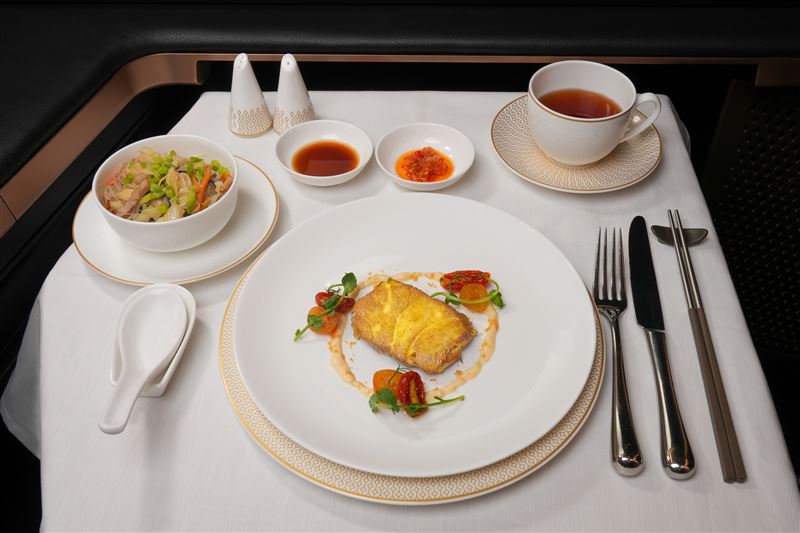頭等艙「睡前套餐」主菜「茶燻海鱸魚」選用紅茶茶葉低溫茶燻，呈現細緻魚肉與淡雅茶香；另一道主菜「元紀炒米粉」則以雞油炒香蝦乾、豬五花與高麗菜，再加入新竹日曬風乾米粉拌炒，重現台灣經典古早味。（圖／星宇航空提供）