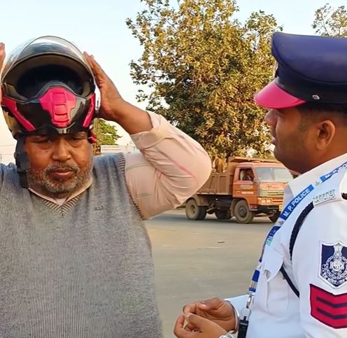 阿伯拿警察的安全帽試戴,頭確實太大,帽子塞不進去。(圖/翻攝自IG)