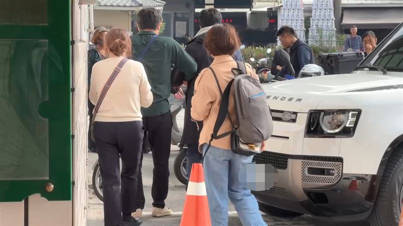 丁女丈夫(綠衣者)攙扶著車禍受傷的兒子前往殯儀館認屍。(圖/翻攝畫面)
