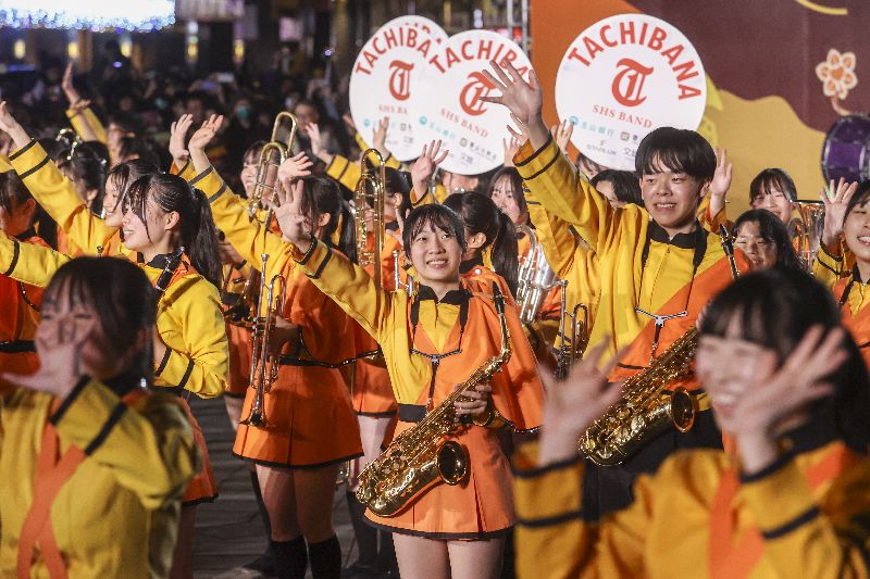 「橘色惡魔」日本京都橘高校吹奏樂部至台北中山堂廣場演出，成員們微笑揮手向現場熱情粉絲致意。（圖／中央社）