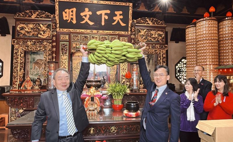 台中一中校長林隆諺(圖右)到文昌公廟祈福，高抬一串青蕉，寓意考生考上「台清交」。(圖／翻攝自台中一中臉書)