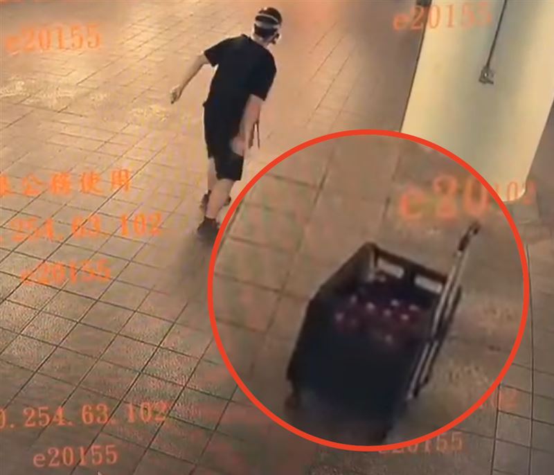 男子丟擲點燃的煙霧彈，箱子中疑似還有很多顆。（圖／翻攝畫面）