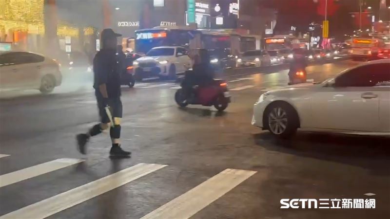 台北車站一帶爆發砍人案，嫌犯北捷中山站外的馬路上丟擲煙霧彈。（圖／翻攝畫面）