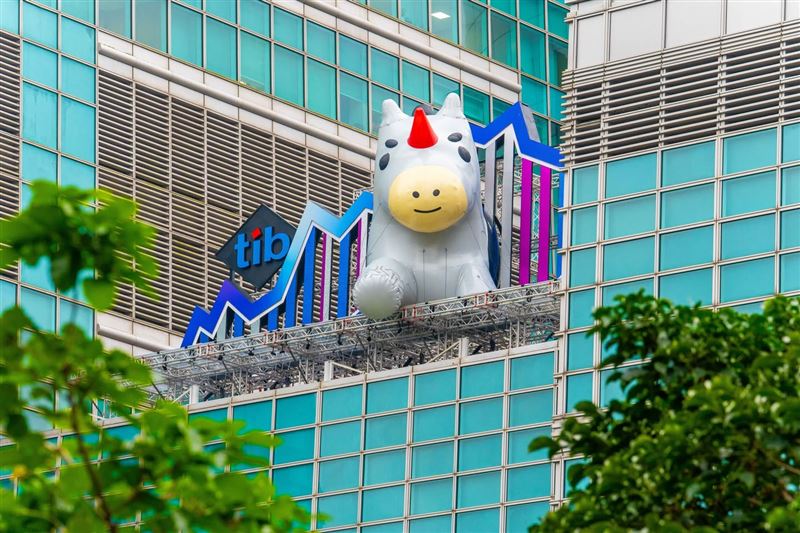 證交所吉祥物tibit躍上台北101！即日起至12月底，巨型裝置隨夜色展演呼吸燈光，成信義區打卡新亮點。同步推出16款免費LINE動態貼圖，下載使用或參與AR濾鏡拍照打卡，就有機會抽中iPhone 17 Pro、MacBook Air等豪禮，邀全民感受創新能量。（圖／證交所提供）