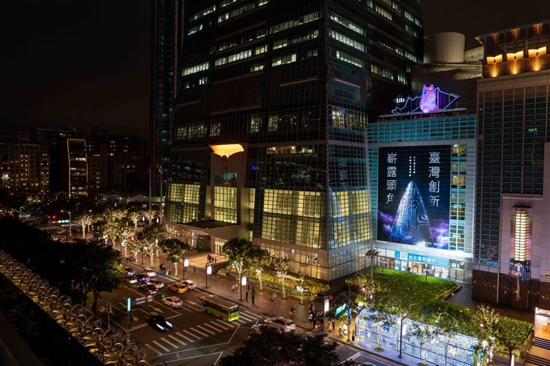 證交所吉祥物tibit躍上台北101！即日起至12月底，巨型裝置隨夜色展演呼吸燈光，成信義區打卡新亮點。同步推出16款免費LINE動態貼圖，下載使用或參與AR濾鏡拍照打卡，就有機會抽中iPhone 17 Pro、MacBook Air等豪禮，邀全民感受創新能量。（圖／證交所提供）