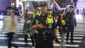 北捷隨機傷人案　警持長槍加強戒備男子張文19日接連於捷運台北車站地下通道、中山站外丟擲煙霧彈、持刀傷人，之後闖入百貨墜樓不治。圖為中山站外晚間有員警持長槍加強戒備。（珍惜生命，自殺不能解決問題，生命一定可以找到出路。若須諮商或相關協助，可撥衛福部專線「1925」、生命線專線「1995」或張老師服務專線「1980」。）中央社記者鄭清元攝　114年12月19日