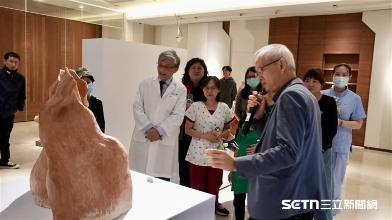 鄭良珊醫師細心地向大家介紹自己的作品，可以感受到一名外科醫師在冰冷刀鋒之外，那份厚實而溫熱的人文情懷。他指尖掠過陶土的起伏，彷彿在撫平多年來在診間見證的無數傷痕，將診斷的精準化作創作的深情。（圖／院方提供）