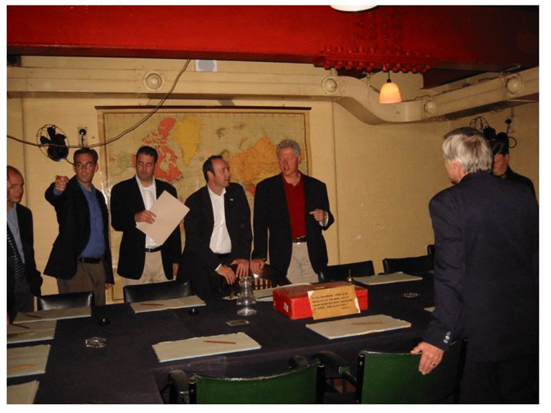 被公開檔案中，美國前總統柯林頓（穿紅衣）與影帝凱文史貝西（柯林頓身旁左邊）同框的照片。（圖／翻攝自X平台 @ElizLanders）