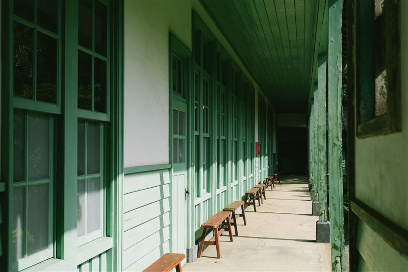 北投中心新村木造走廊延伸，午後光影灑落窗框與長椅，空間靜謐而緩慢。（圖／翻攝畫面）