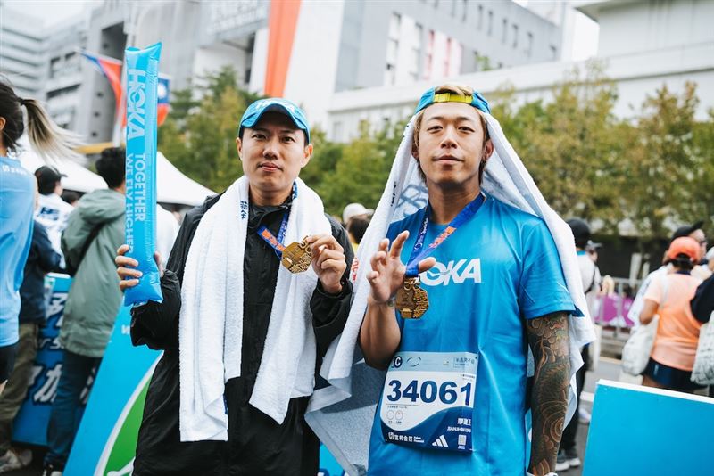 兩人在終點線後秀出完賽獎牌，正是Together We Fly Higher最佳寫照。（圖／品牌業者提供）