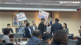 民進黨立委手持抗議手牌衝上主席台敲桌高喊「有異議」。（圖／記者詹宜庭攝影）