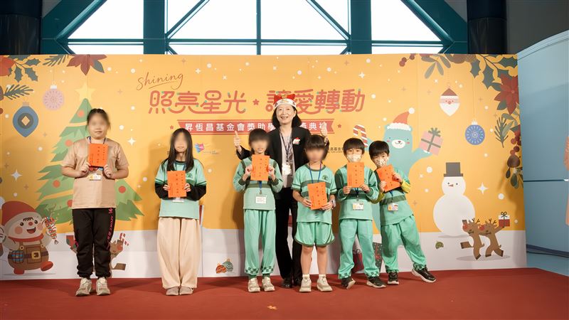 高雄國際航空站主任王郁珍（戴聖誕帽者）頒發獎助學金勉勵學童（圖／昇恒昌基金會提供）