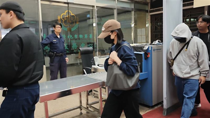 劉女此次被傳喚，穿大學T，戴潮帽、口罩全身包緊緊。（圖／翻攝畫面）