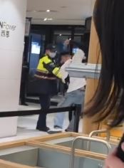 男子和警方拉扯，做出揮舞拳頭和過肩摔的動作，目擊民眾驚呼：「太恐怖了。」（圖／翻攝自Threads @perseus_220）