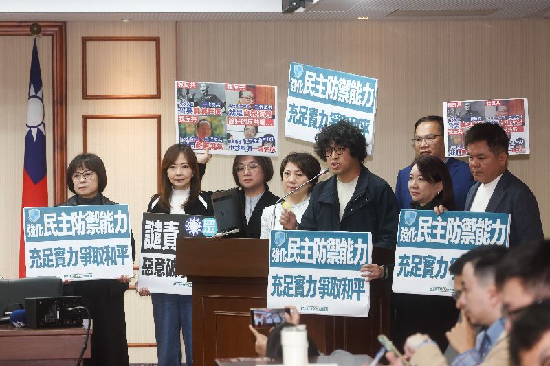 立法院30日舉行程序委員會，民進黨立委沈伯洋（左5）率黨團立委舉牌發言，批評藍白立委攜手持續阻擋國防相關預算排案審查