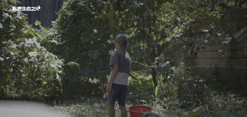 影片中，他熟練地曬衣服、為菜田澆水、餵豬、洗碗，甚至替媽媽煮泡麵，小小身影在破舊屋內穿梭，肩上的責任卻早已超過同齡孩子。（圖／點燃生命之火提供）