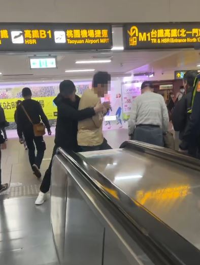 台北車站陳男失控咆哮,「黑衣人」見狀立馬出手,協助警方壓制。(圖/翻攝自Threads@xry_912)