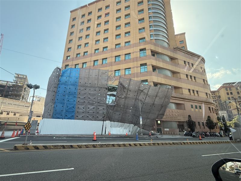 台中榮總第二醫療大樓旁工地，疑因強風吹襲導致鷹架圍籬傾倒。（圖／翻攝畫面）