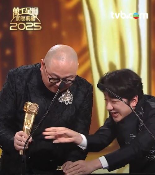 林盛斌（左）激動發言時意外將獎盃敲斷，王祖藍（右）在旁幽默調侃：「TVB開台以來第一位敲爛獎座的人，落地開花！」。（圖／翻攝自TVB FB）